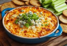 Create a vertical Pinterest Pin (2:3 ratio) for Fast Party Buffalo Chicken Dip. Style: fun, energetic party appetizer vibe. Show a hot, bubbling buffalo chicken dip in a colorful baking dish with melted cheese and buffalo sauce drizzle. Garnish with green onions. Surround with tortilla chips, celery sticks, and party napkins. Setting: game-day or party table. Lighting: bright, inviting, mouthwatering. Text overlay (bold, high-contrast font): “Fast Party Buffalo Chicken Dip” Subtext: Ready in Minutes • Crowd Favorite Clean layout, Pinterest-optimized, no clutter.